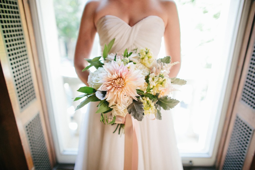 Bride holding her bouquet of flowers in blush, grey, and ivory flowers with with cafe au lait dahlias.