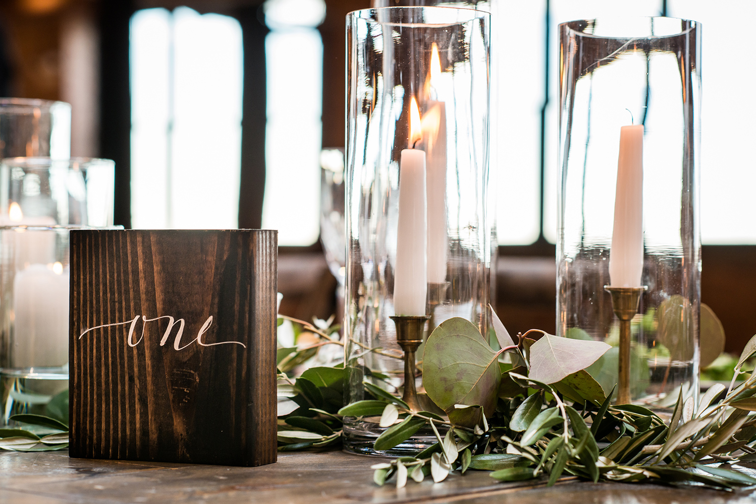 Wedding head table garland, brass candlesticks, wooden table number.