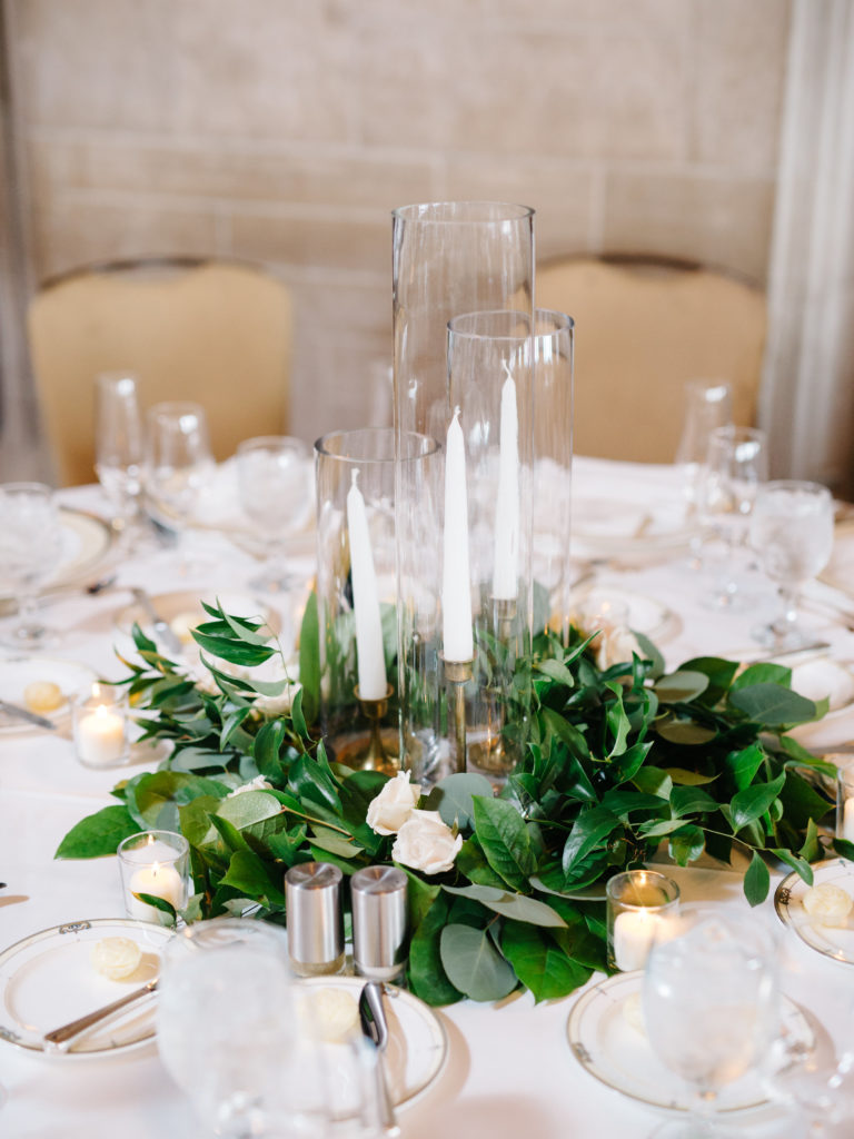 Wedding centerpiece with taper candles and garland.
