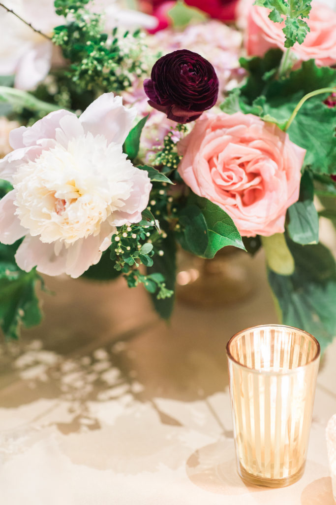 Detail of centerpiece with burgundy ranunculus, blush peonies, coral roses, spirea.