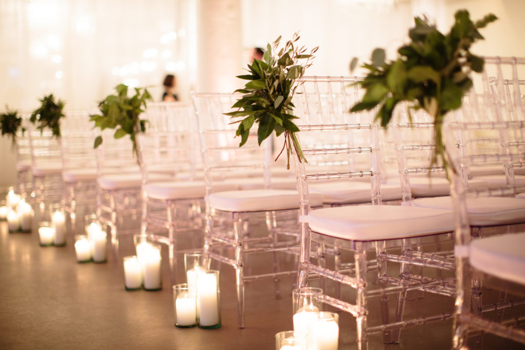 Wedding ceremony aisle candles with foliage chair garlands