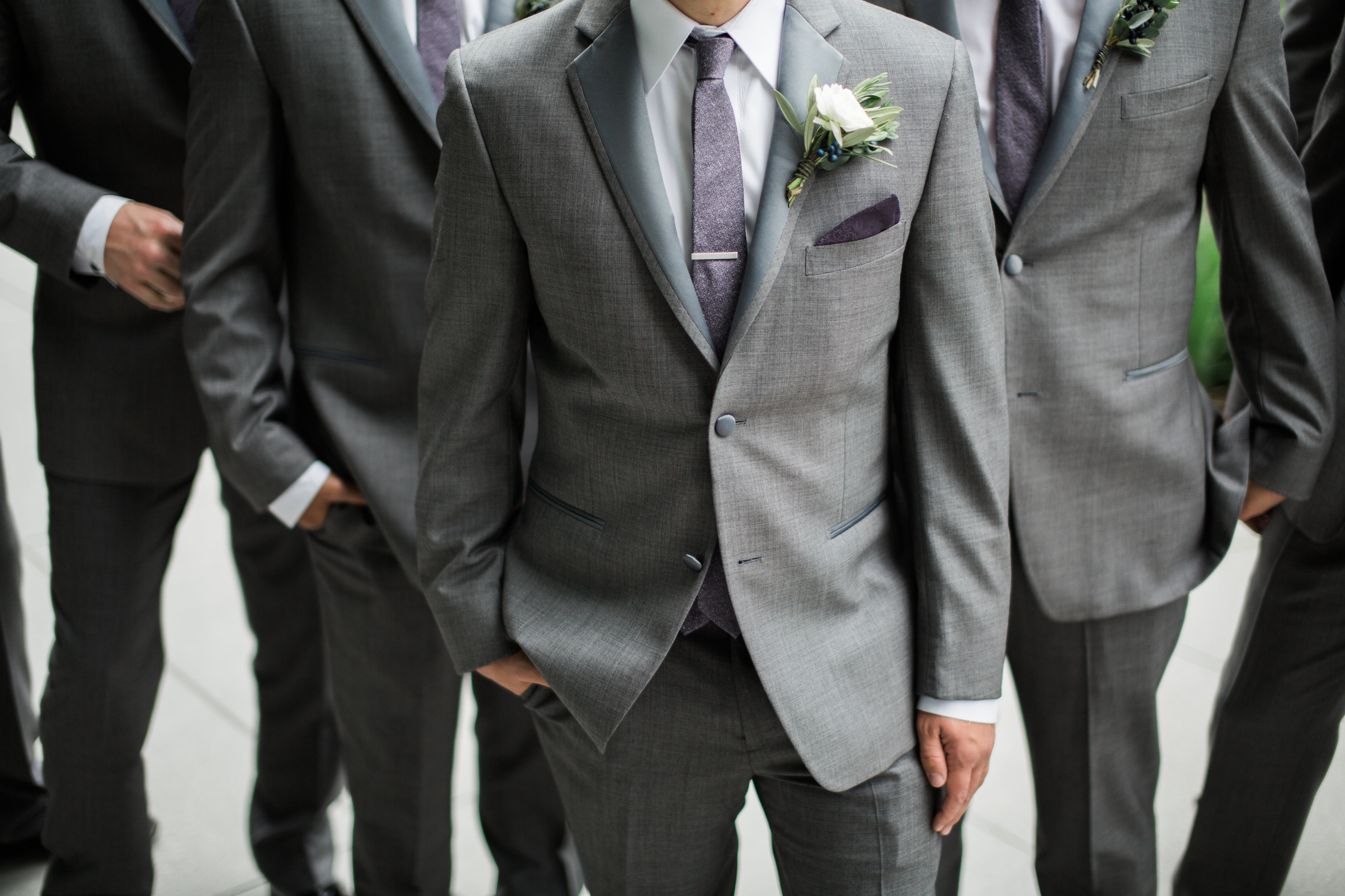 groom in grey suit with eggplant tie and boutonniere