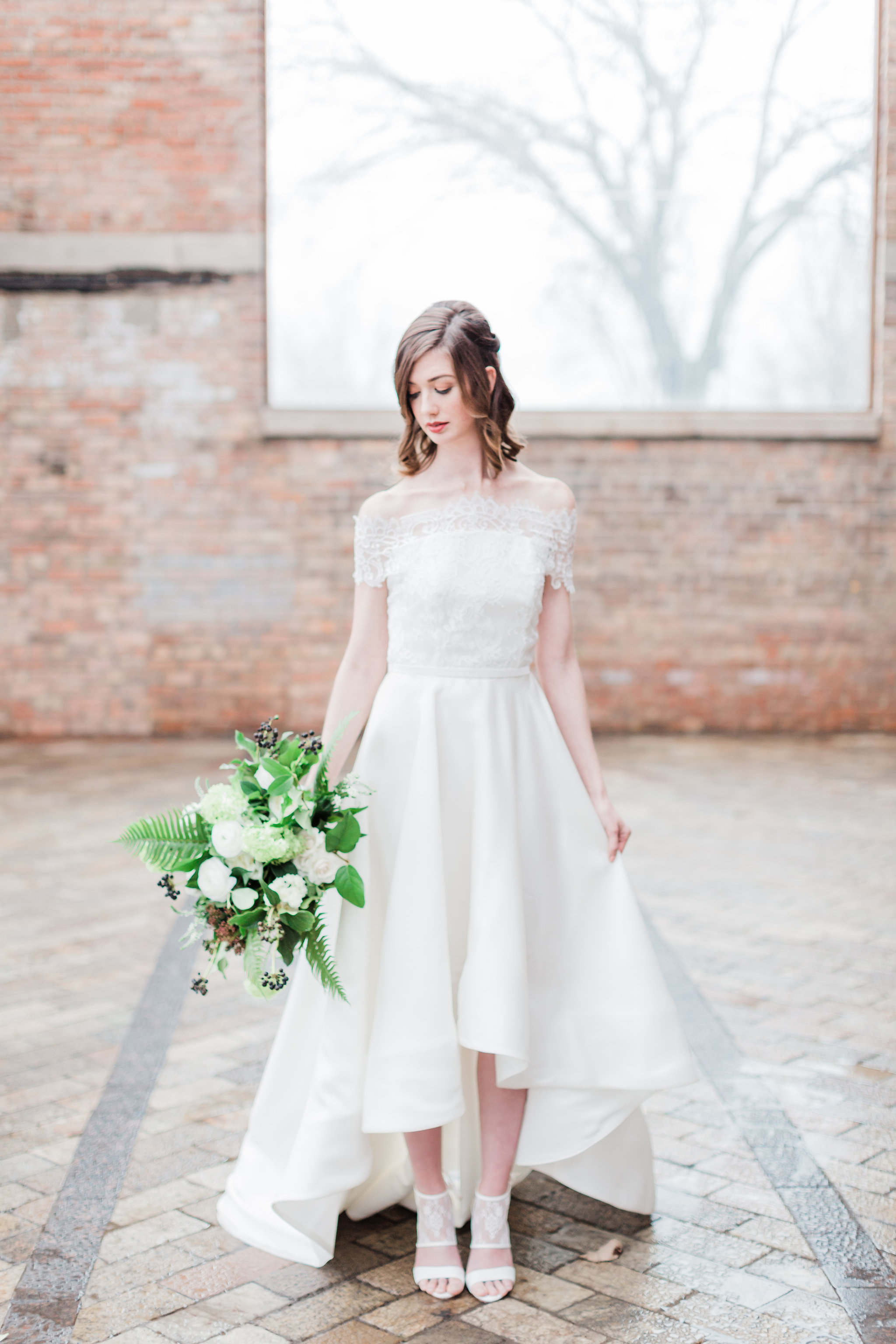 Bride holding white and green winter wedding bouquet.