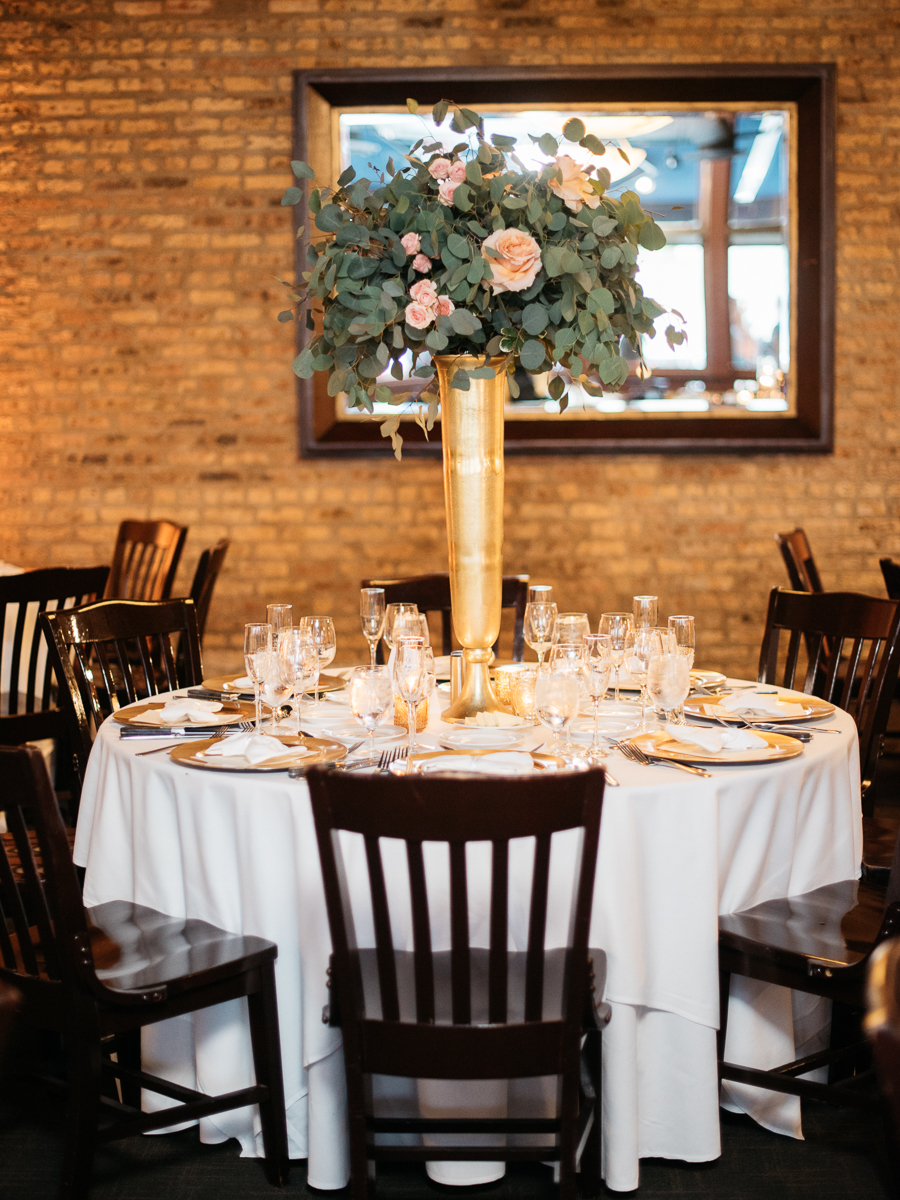 Tall centerpiece arrangement at gold and white wedding reception table at River Roast Chicago with peach roses and eucalyptus.