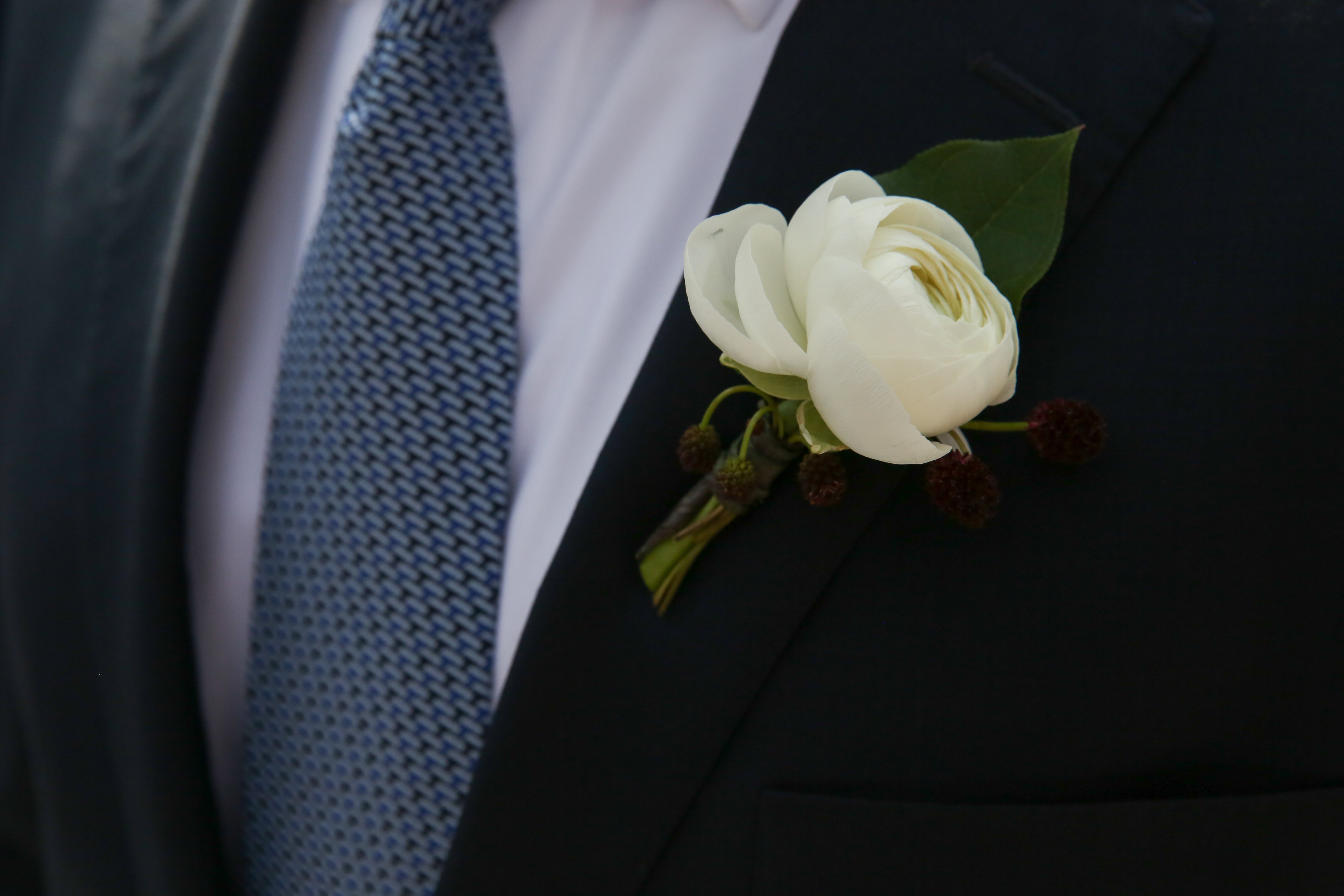 Groom's simple classic white ranunculus boutonniere for Spring wedding.