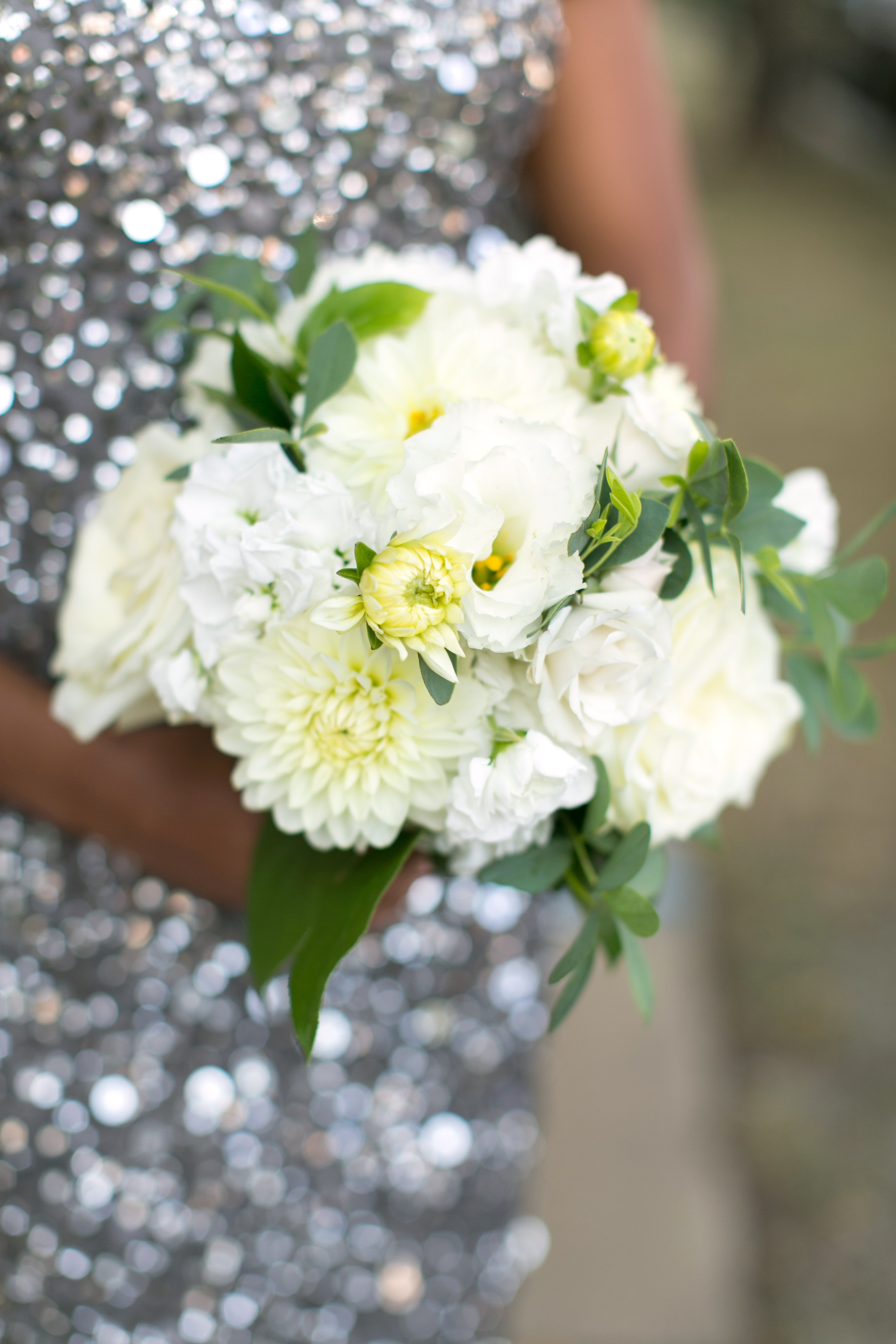 White and golden bridesmaid's bouquet with silver sequined dress.