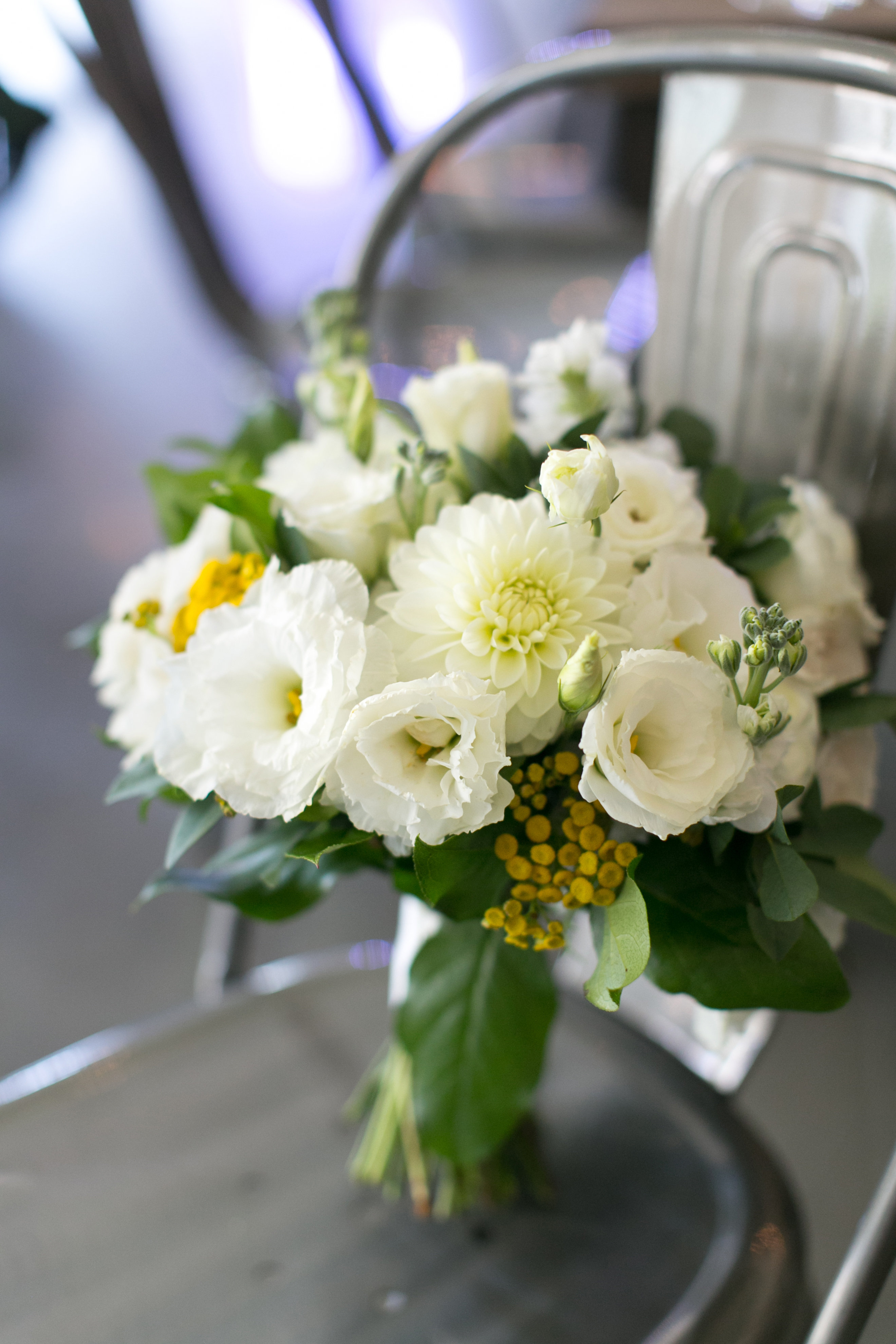 Yellow and ivory wedding bouquet with lisianthus and dahlias in contemporary venue.