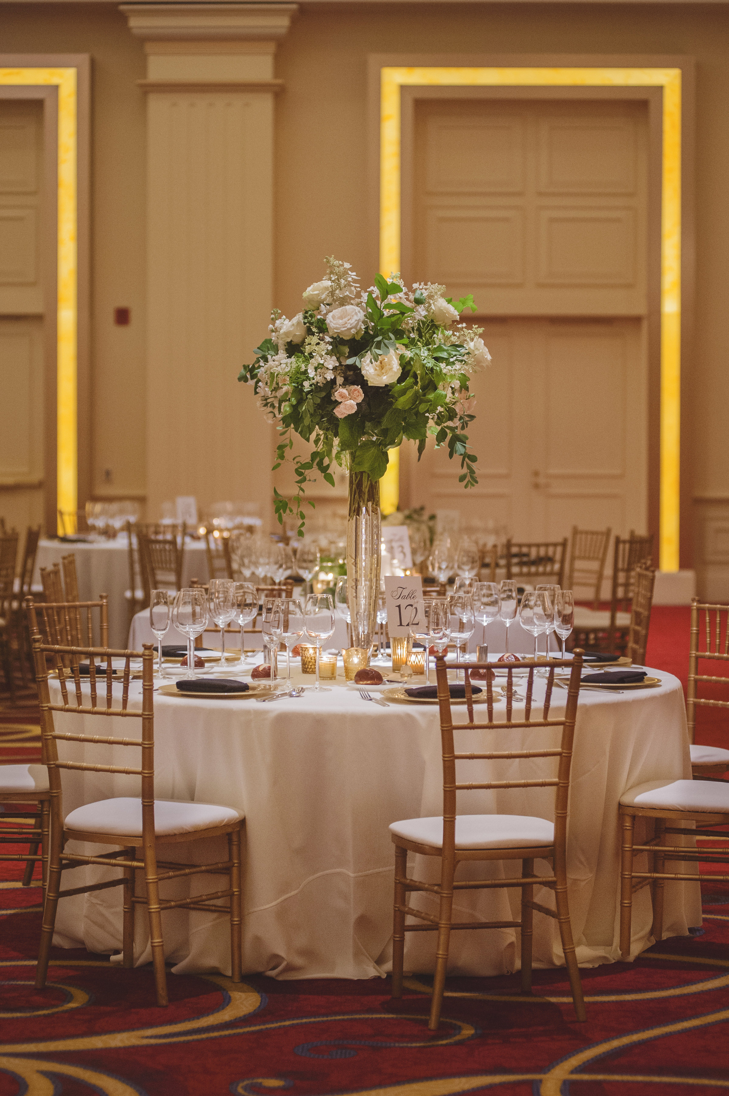 Autumn wedding reception room with classic ivory and green arrangements at JW Marriott Chicago.