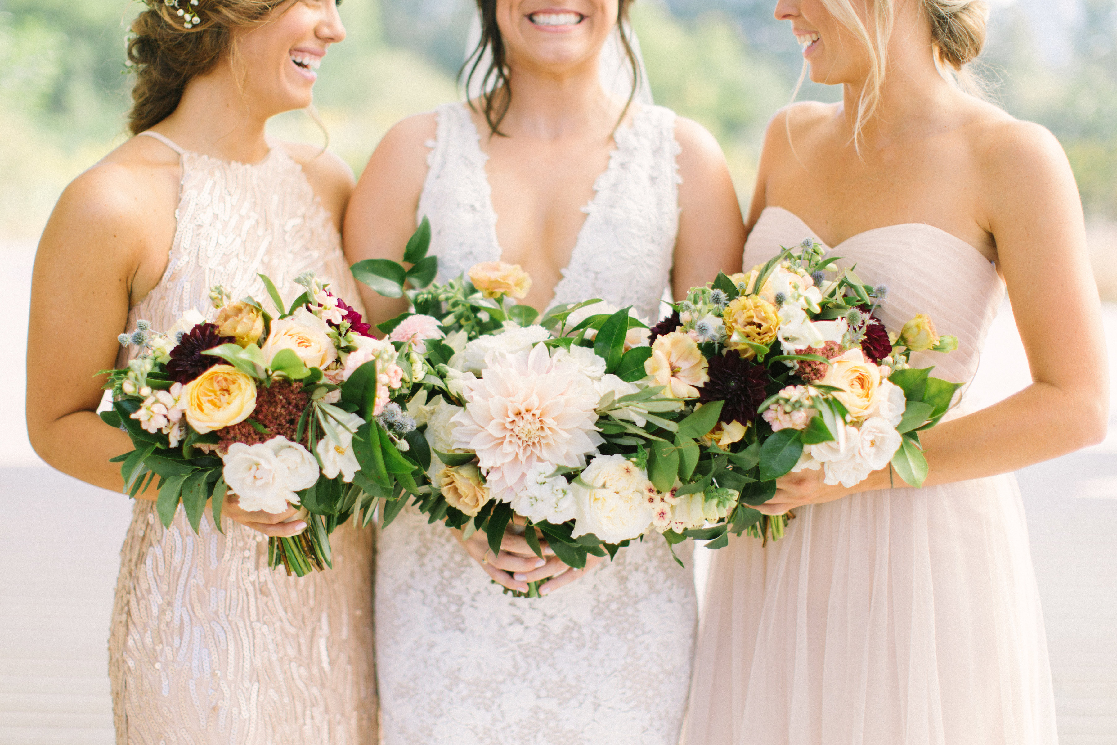 Early autumn wedding, bride and bridal party with neutral bouquets of burgundy dahlias and roses.