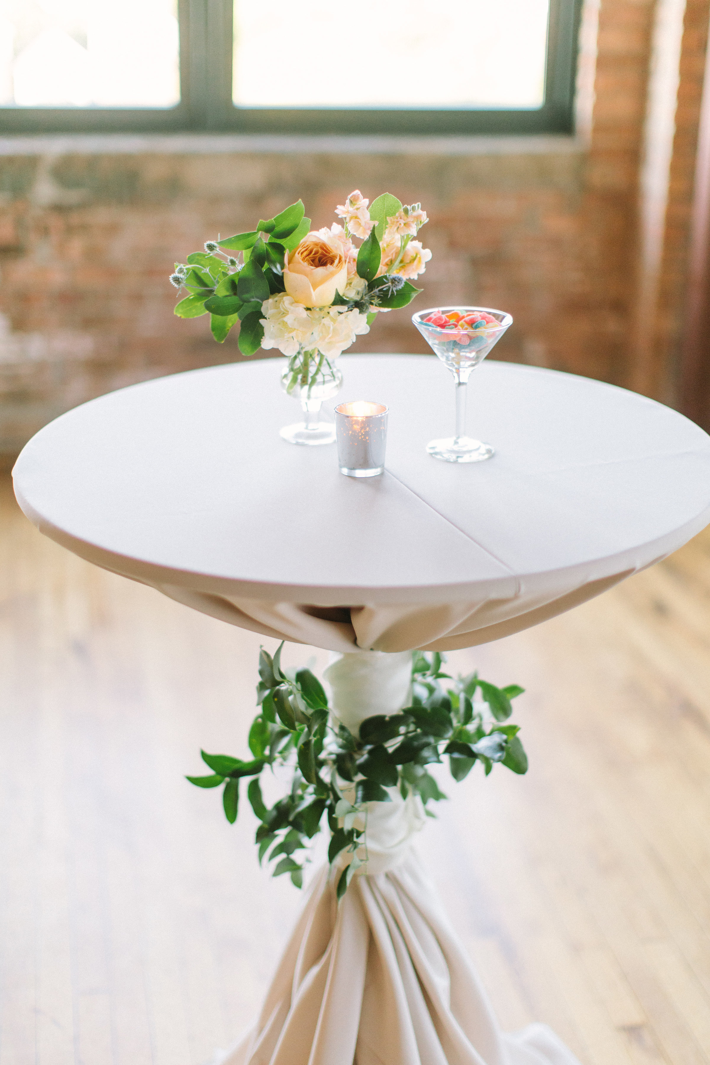 Whimsical reception tables for fall wedding at Bridgeport Art Center with garden-style arrangements. and foliage highboy ties