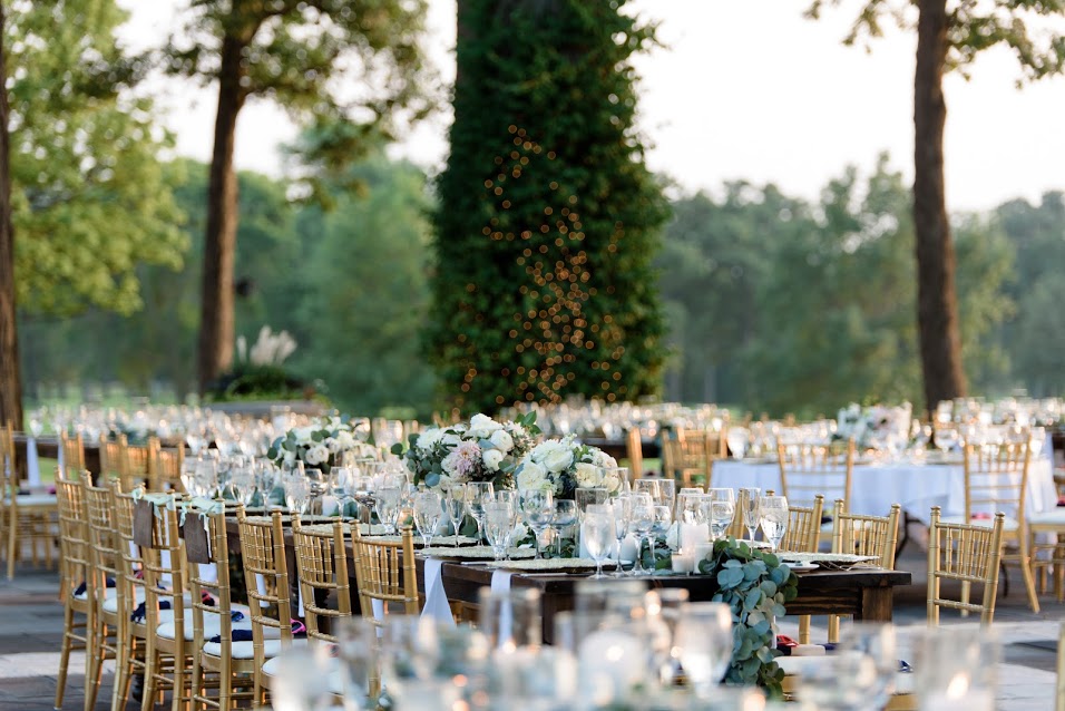 September wedding reception details with gold bamboo chairs and eucalyptus garland.