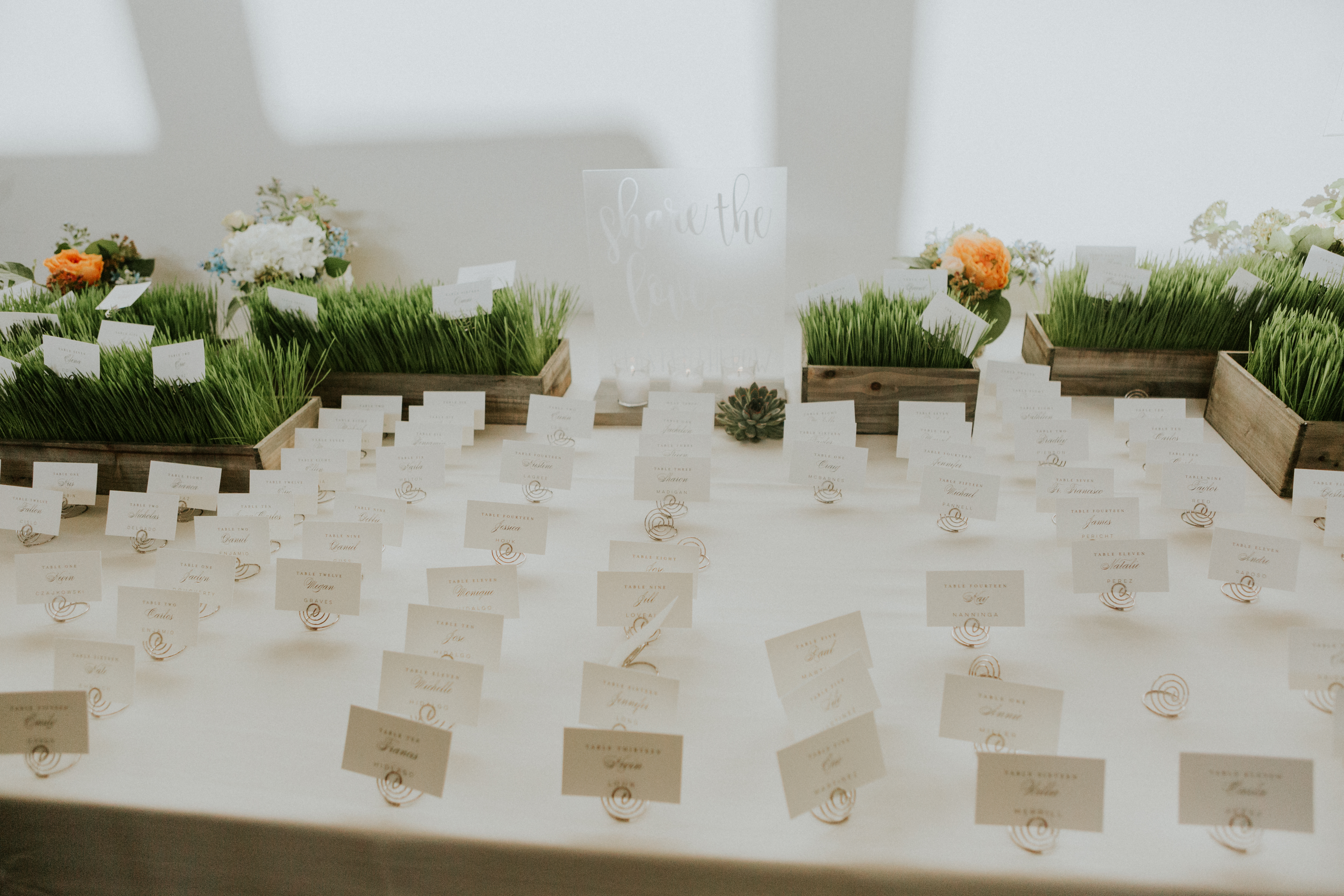 Midsummer wedding table cards with fresh grass decorations in rustic wood boxes.