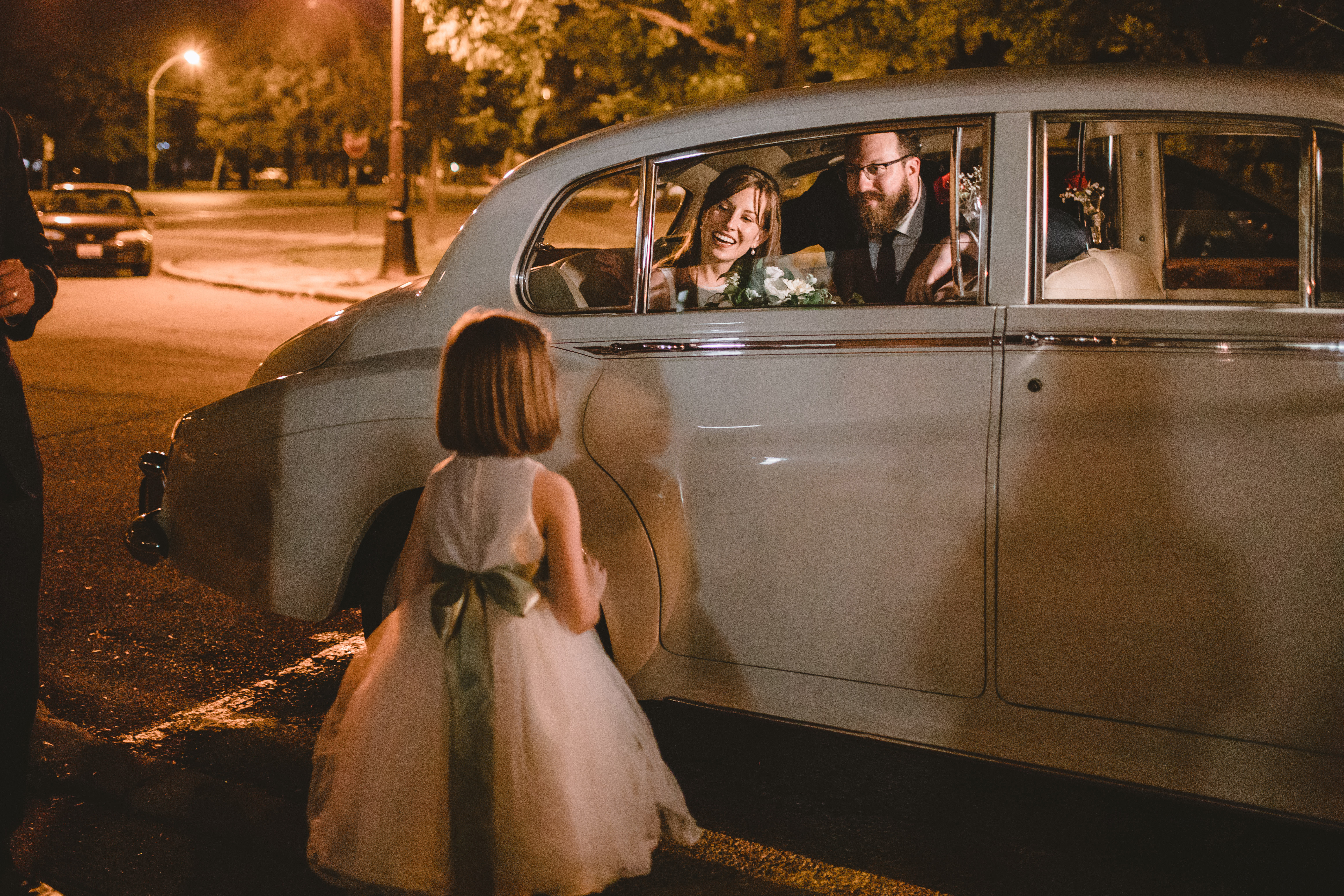 Bride and groom exit in vintage car.