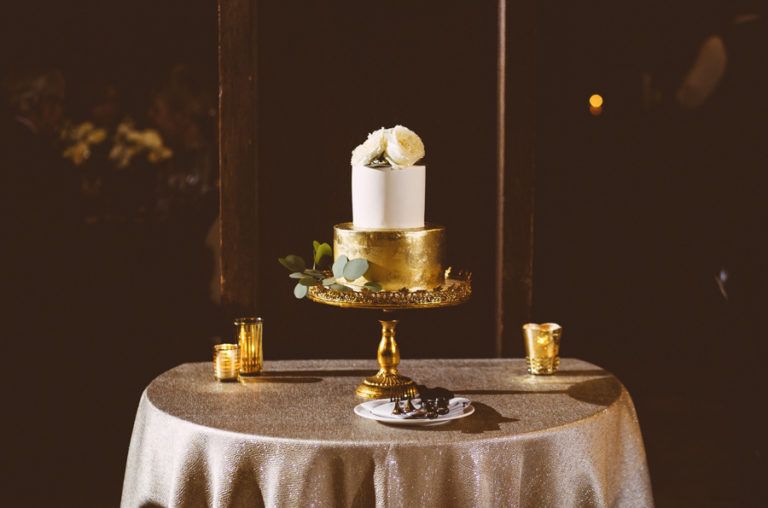 Gilded gold cake at Chicago Athletic Association with white blossoms on top.