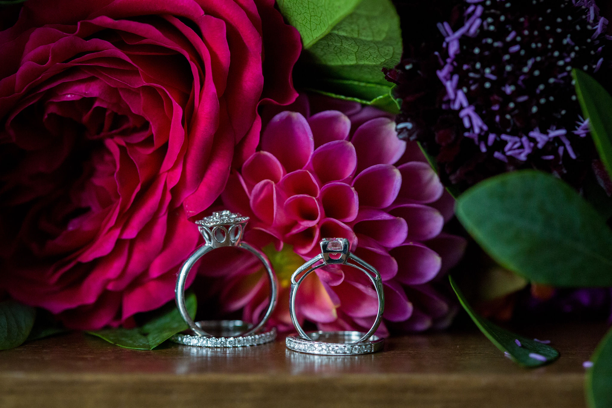 Bride wedding rings with magenta dahlias and garden roses for colorful summer wedding.