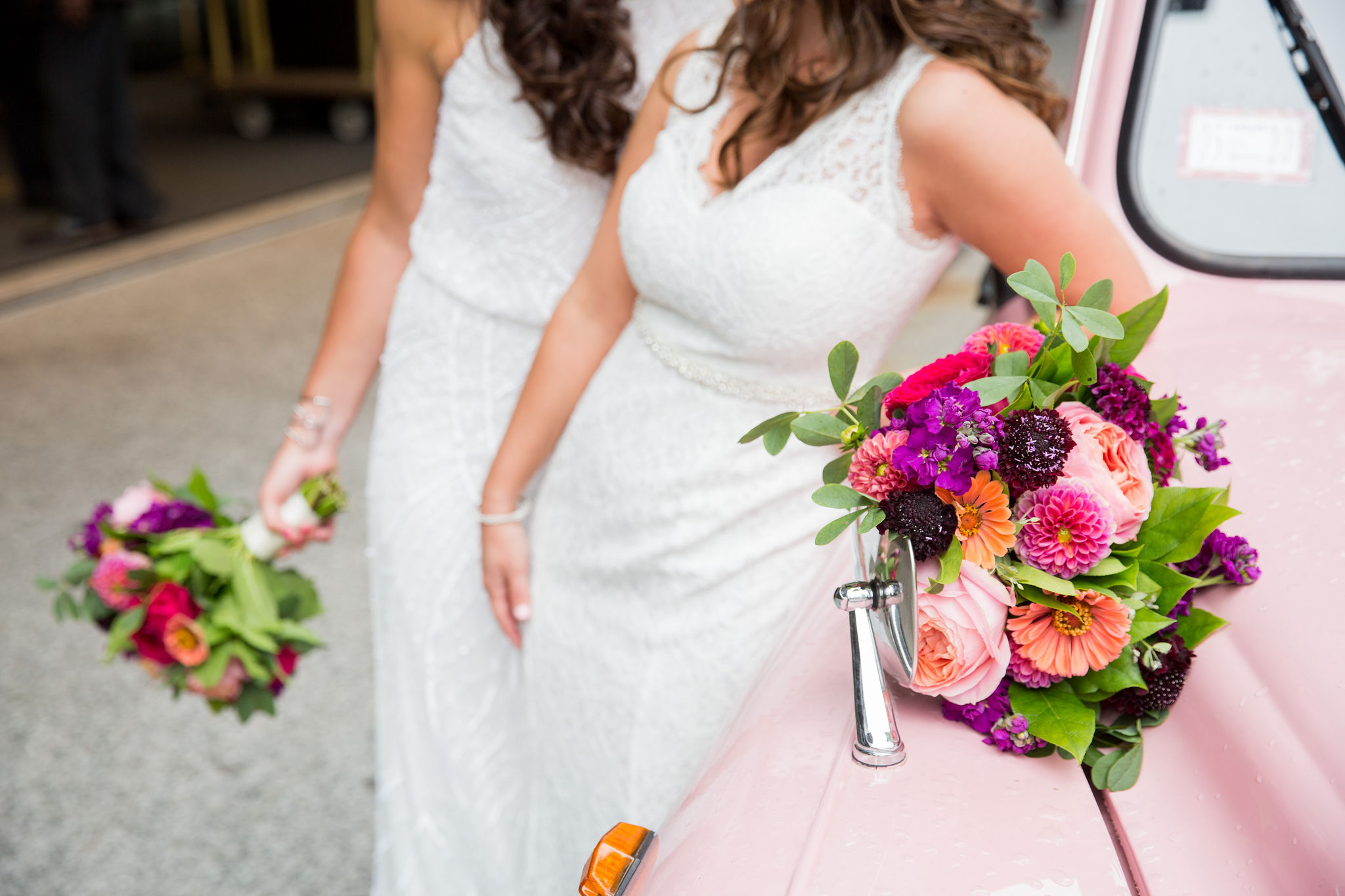 Bright colored bride bouquets with magenta garden roses, dahlias, orange zinnias, purple scabiosa and stock.