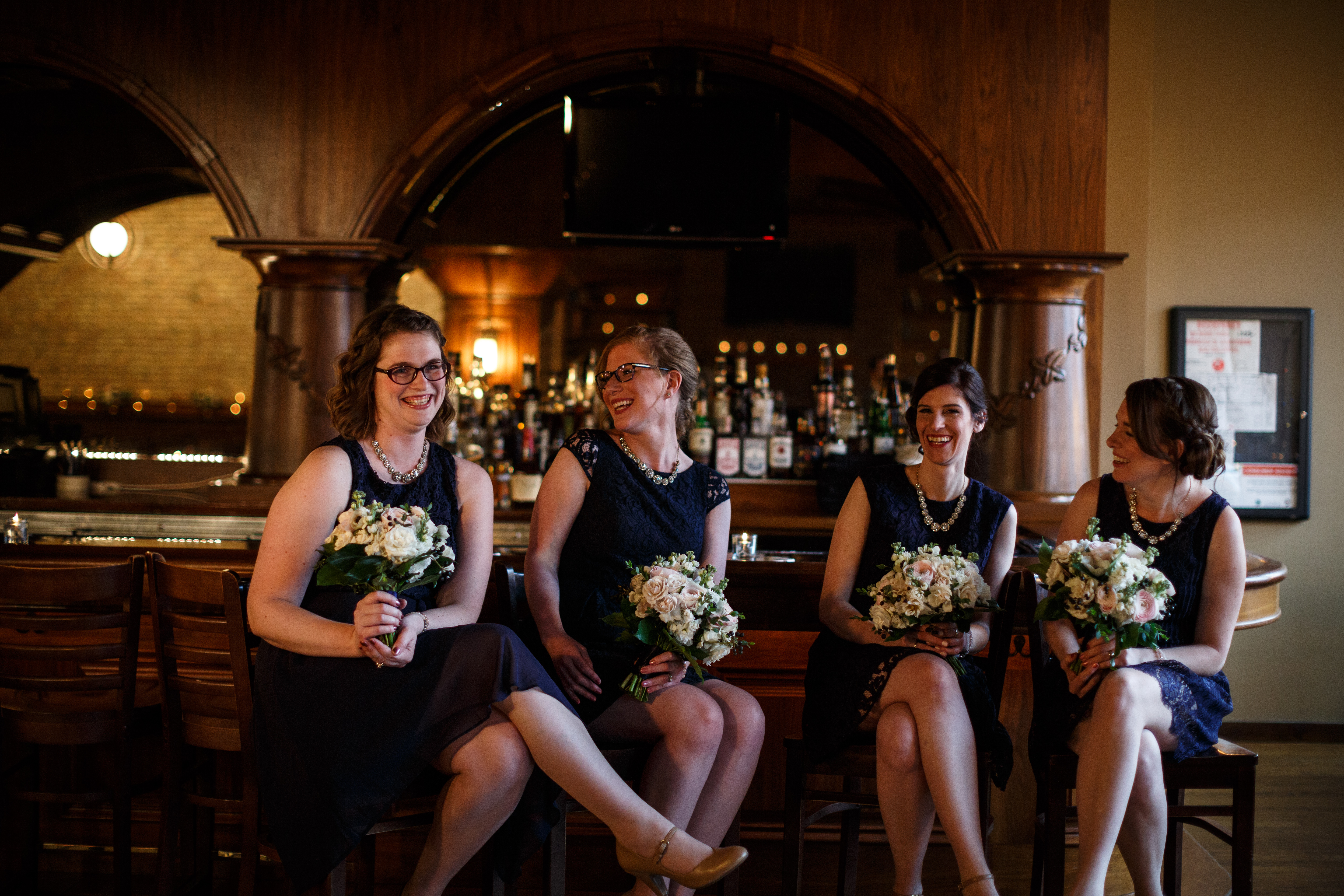 Spring bridesmaids at Revolution Brewing Chicago with pink and white bouquets of ranunculus, roses, and anemones.