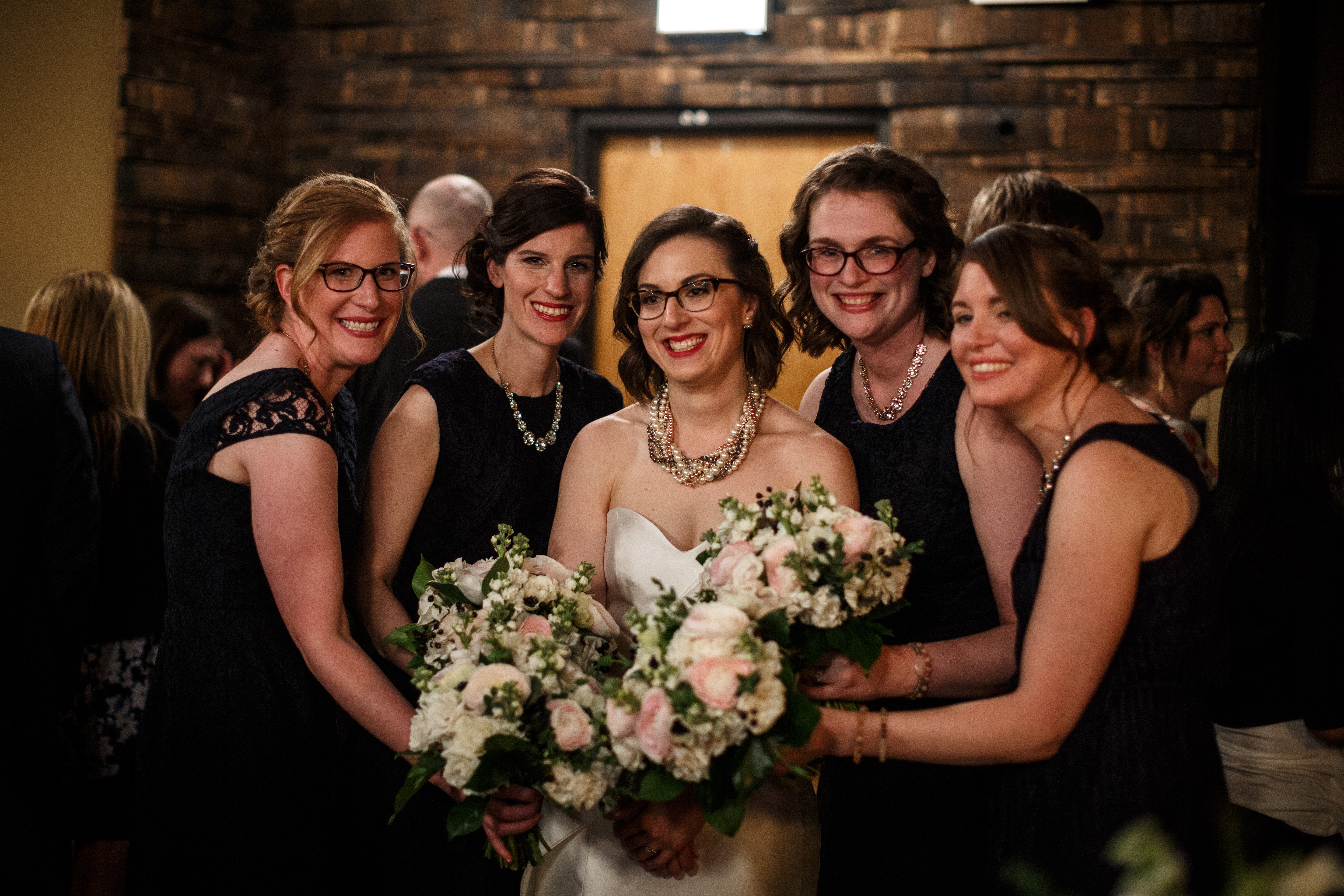 Spring bride and bridesmaids at Revolution Brewing Chicago with pink and white bouquets of ranunculus, roses, and anemones.