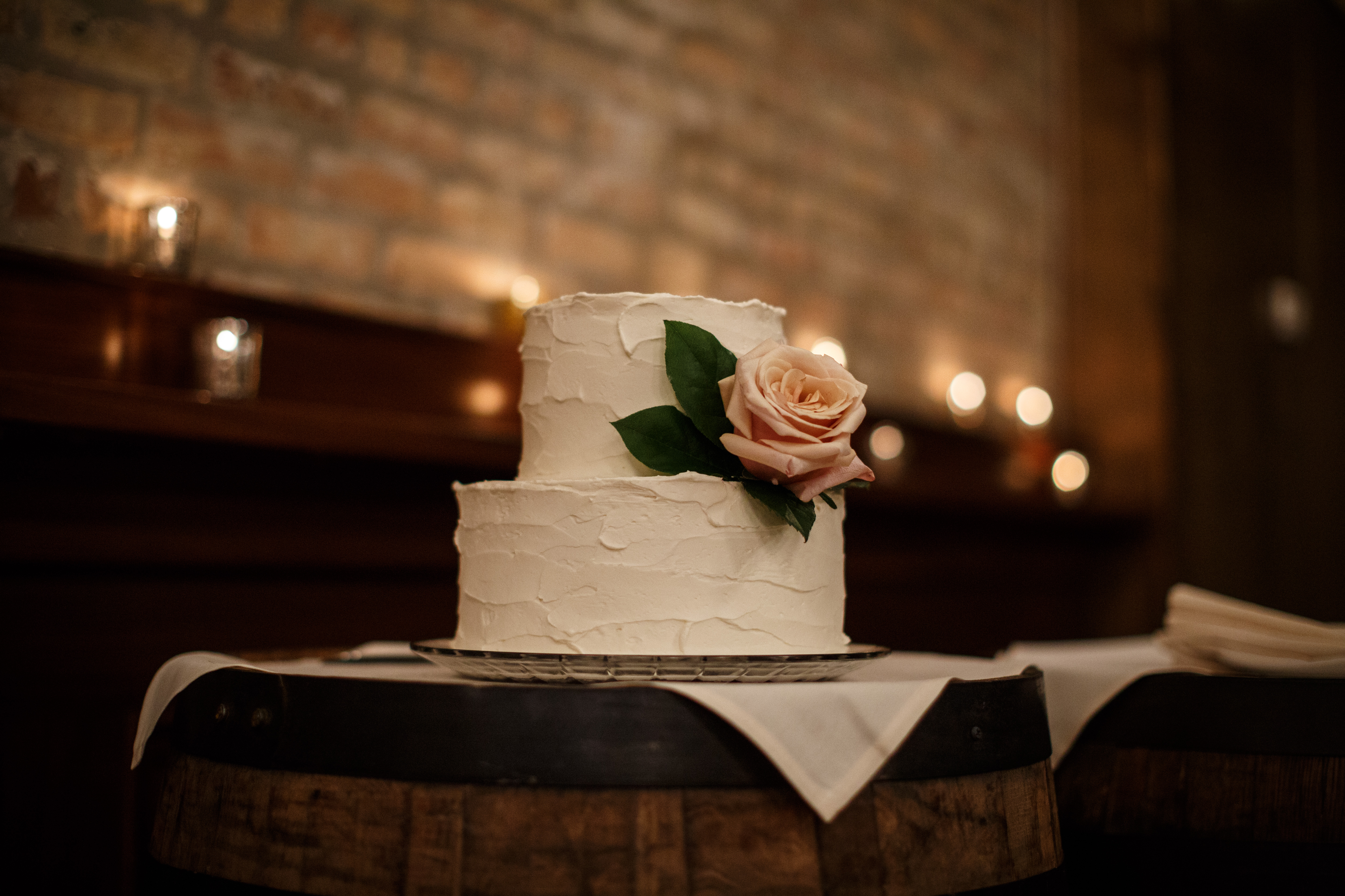 Minimalist white wedding cake with blush garden rose at spring wedding.