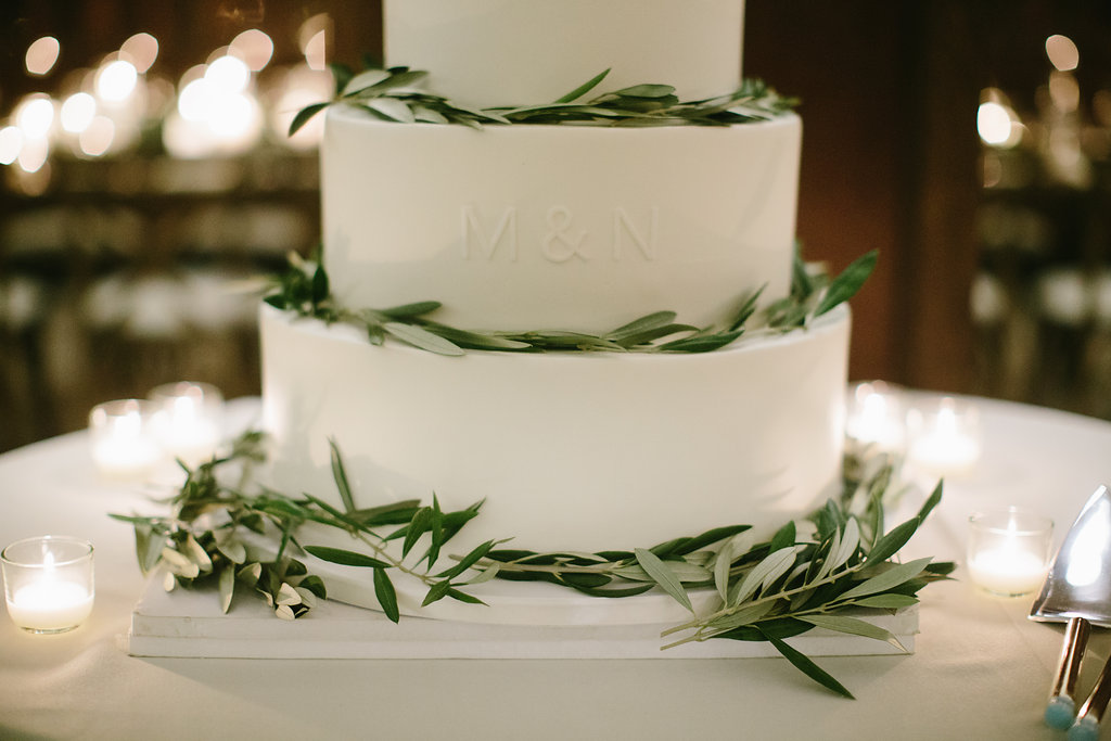 Classic minimal monogrammed cake for winter wedding at Chicago Athletic Association, lined with olive foliage.