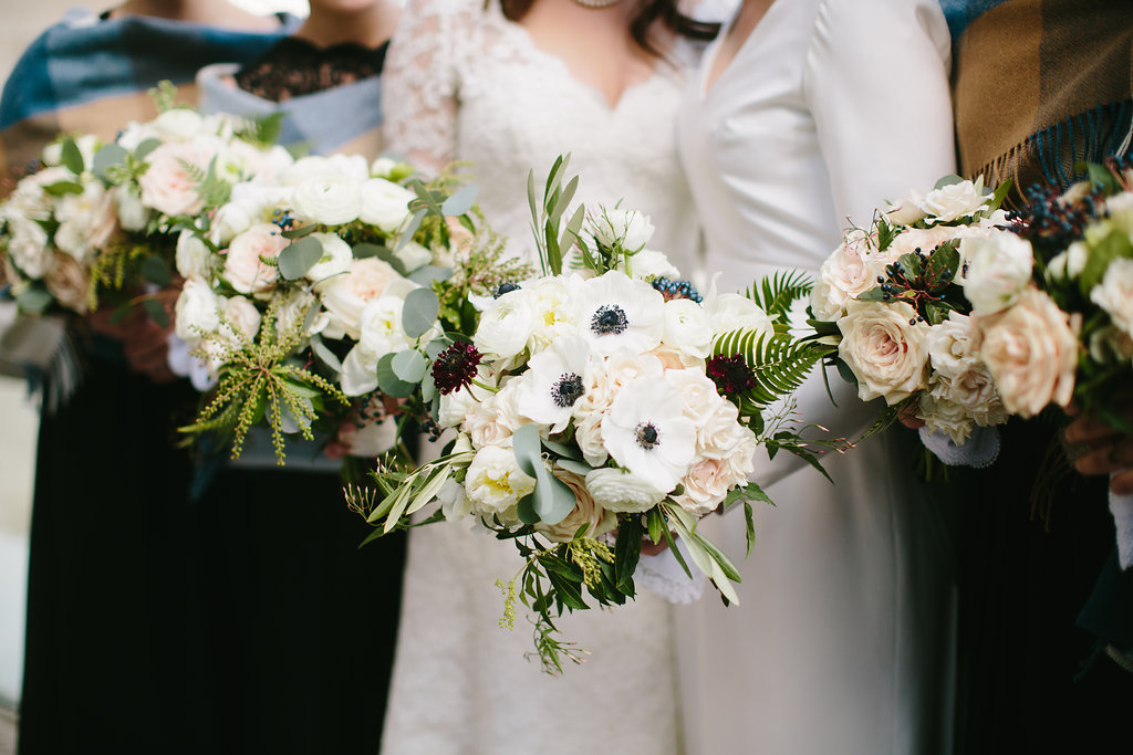 Lush gardeny winter bouquets for wedding with anemones, scabiosa, fern, blush garden roses, and berries.