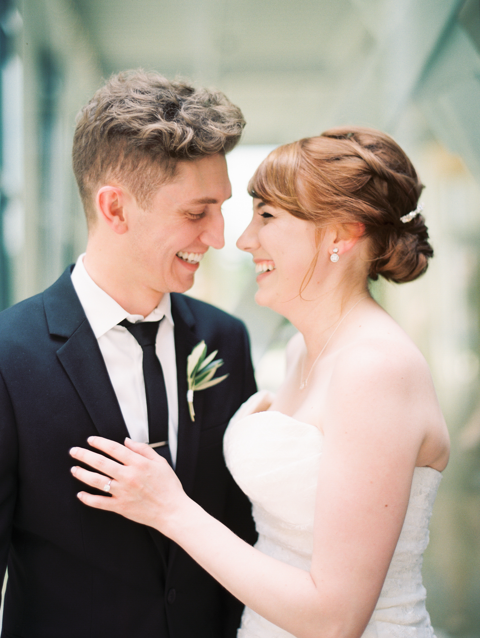 Smiling bride and groom, minimalist monochromatic white wedding with eucalyptus, dahlias, garden roses.