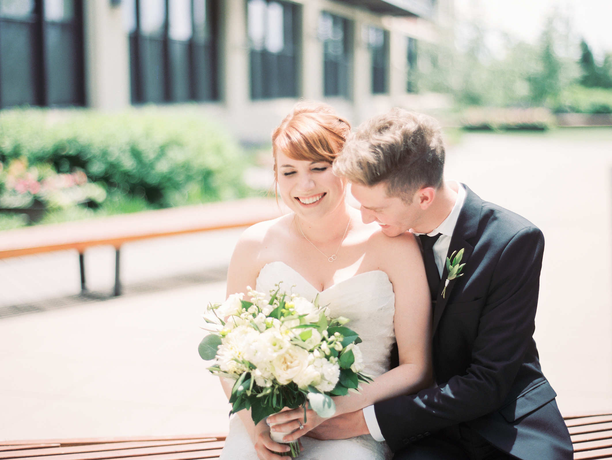 Bride and groom at minimalist and monochromatic Greenhouse Loft wedding with eucalyptus, white dahlias, garden roses.