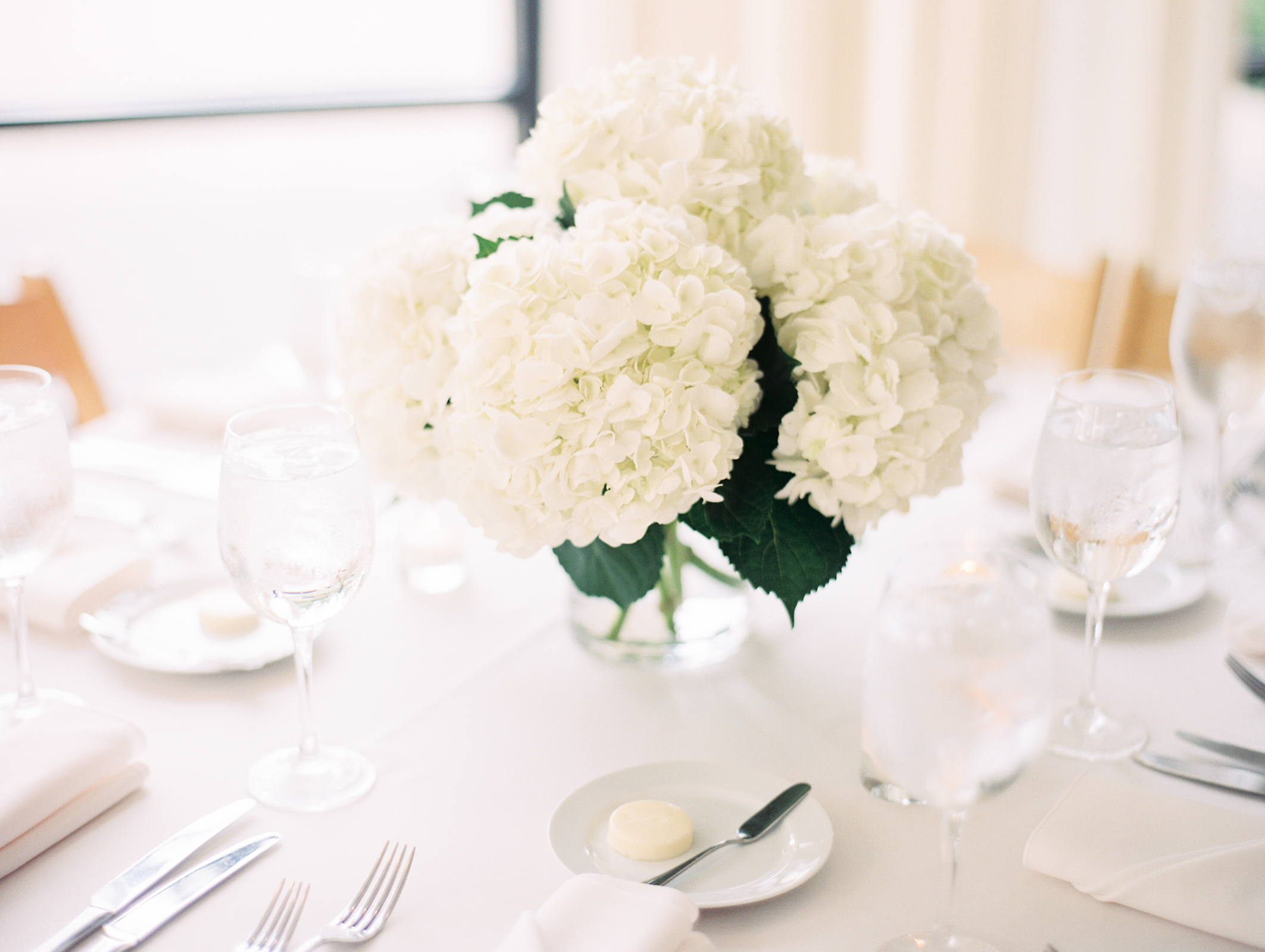 Ethereal minimalist wedding with white hydrangea centerpieces for reception at Greenhouse Loft Chicago.