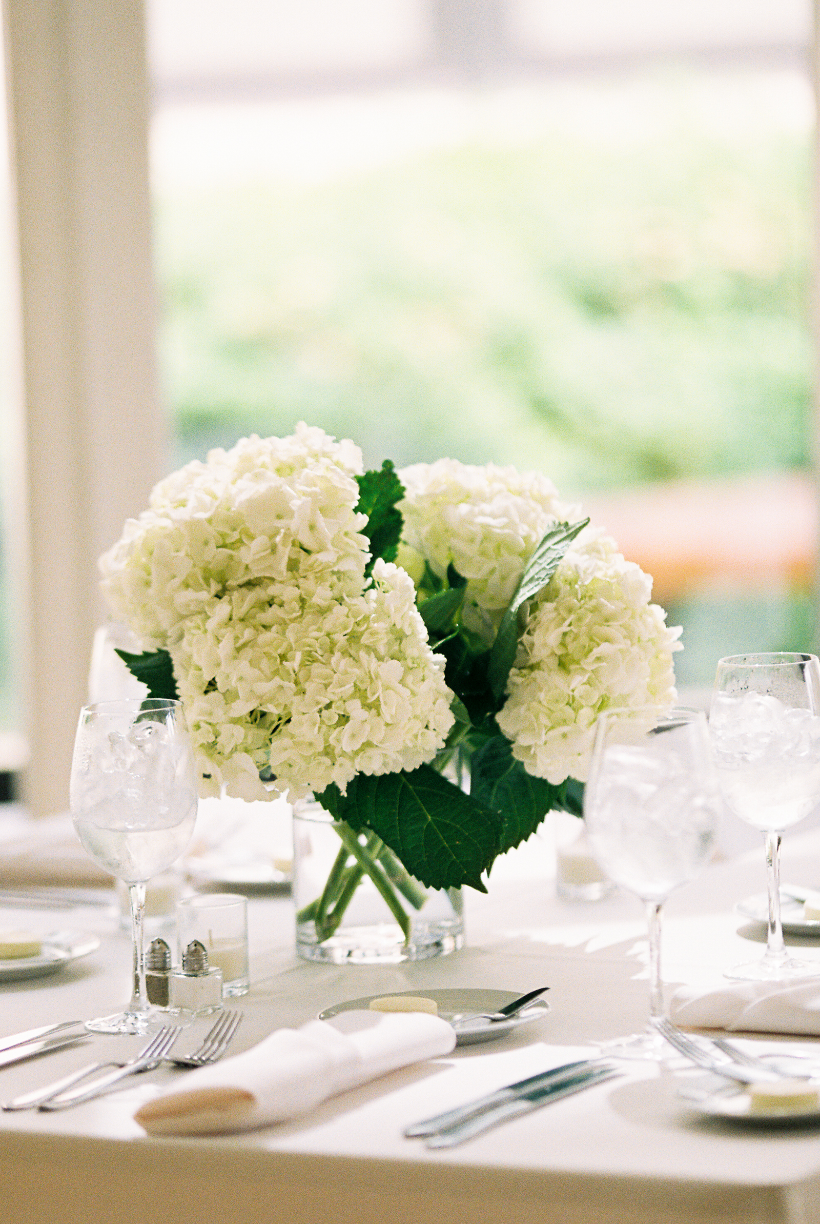 Ethereal minimalist wedding with white hydrangea centerpieces for reception at Greenhouse Loft Chicago.