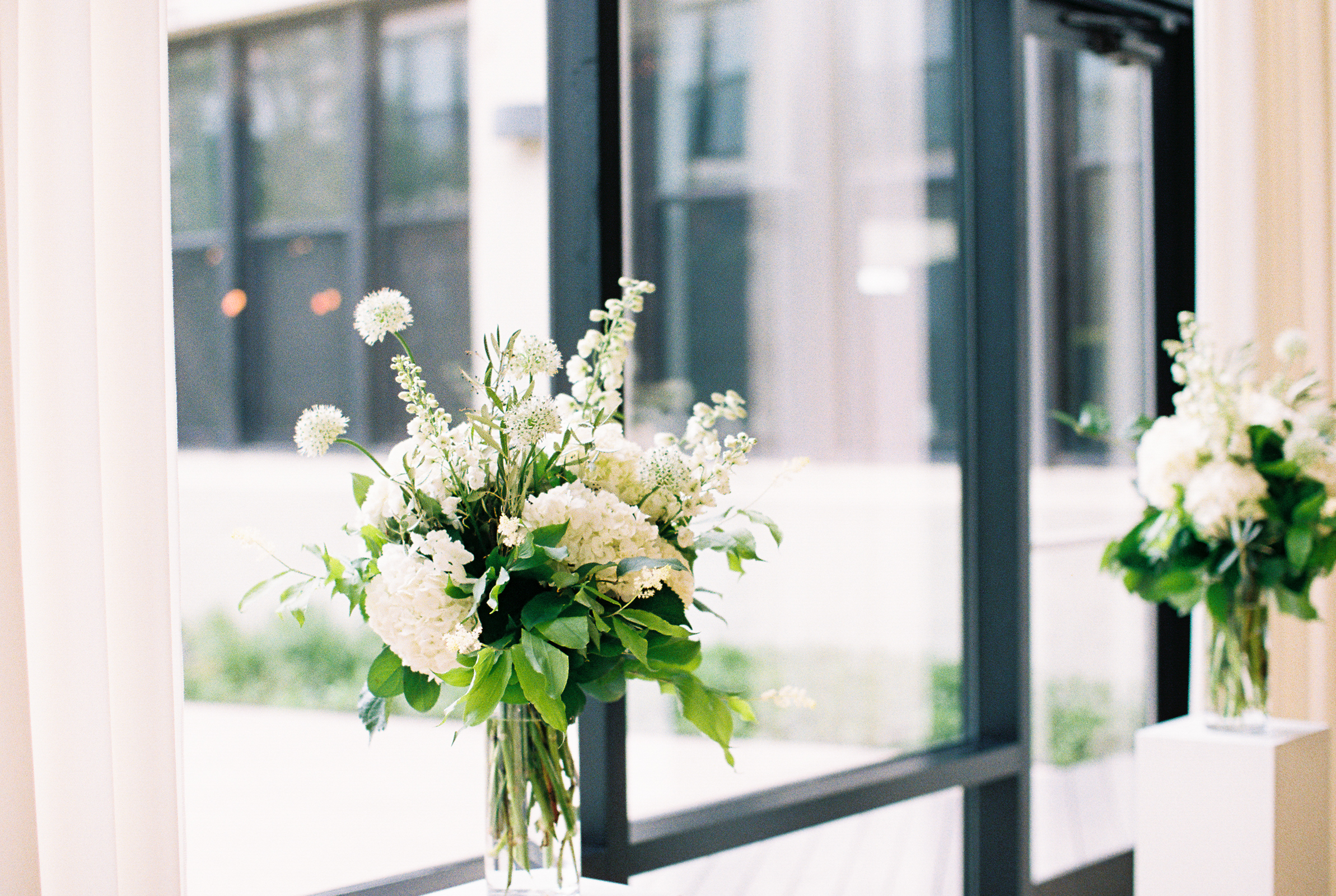 Greenhouse Loft Chicago minimalist and monochromatic wedding with white gardeny altar arrangements of hydrangea.