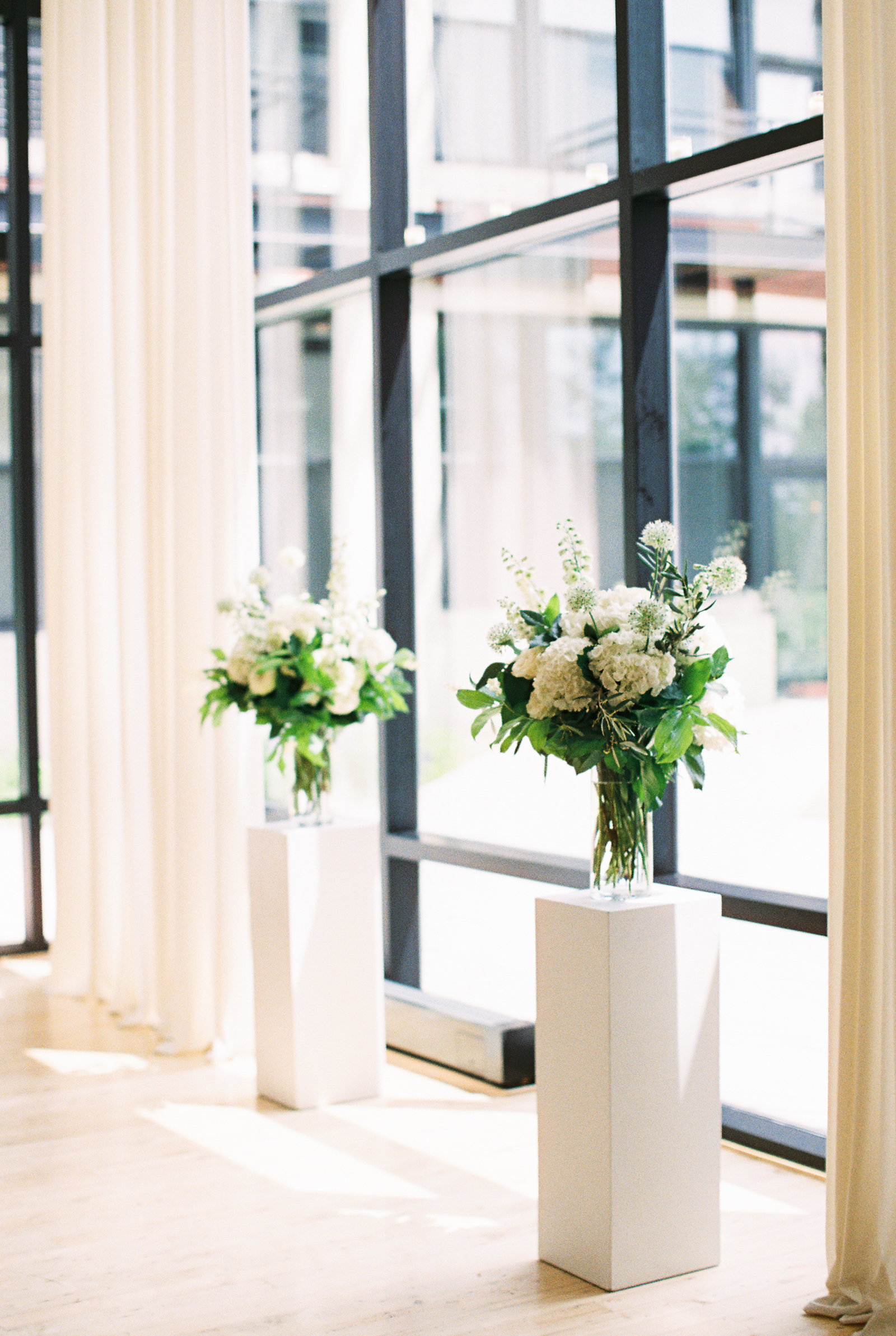 Greenhouse Loft Chicago minimalist and monochromatic wedding with white altar flowers of hydrangea, ranunculus, and garden roses.