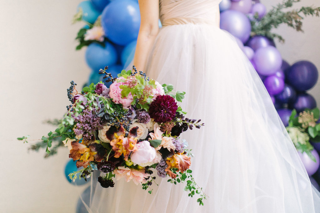 Bride in champagne dress with gardeny bouquet of pink dahlia and peonies, irises, plum scabiosa, hydrangea, berries, tweedia, and lilac.