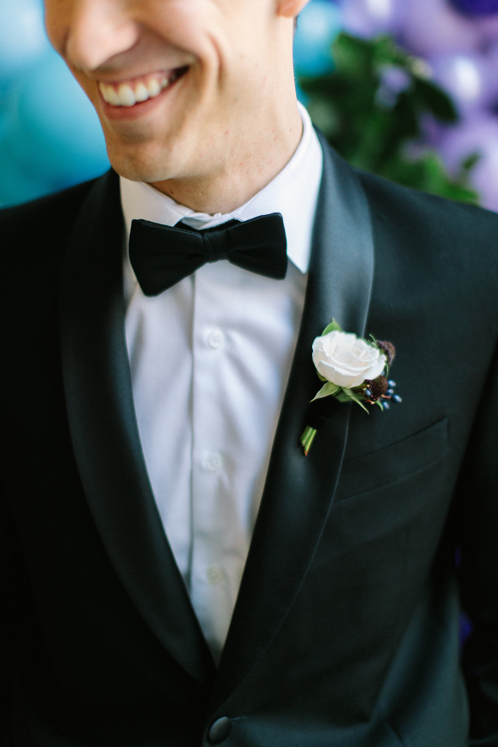 Groom with ivory rose and navy berry boutonniere.