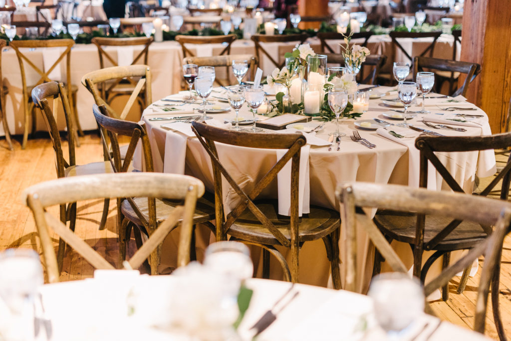 Bridgeport Art Center's Skyline Loft in Chicago wedding reception with rustic tables, foliage and pillar candle centerpieces. 