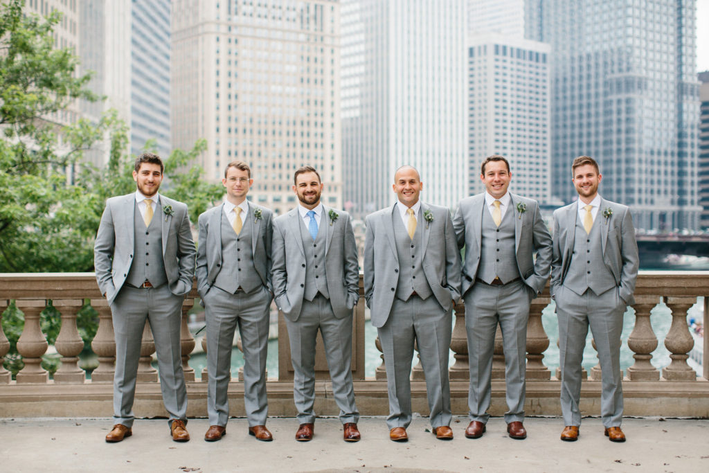 Groomsmen outdoor for summer wedding at Adler Planetarium with blue and pale yellow ties and boutonnieres of thistle, hypericum berries, and rosemary.