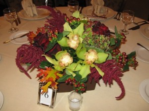Centerpiece with amaranth, oak leaves, hypericum berries, and orchids.