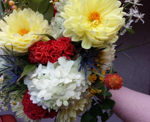 Summer wedding bouquet in coral, yellow, and blue.
