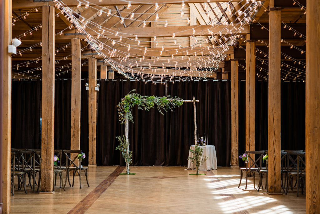 Bridgeport Art Center's Skyline Loft in Chicago with foliage covered wooden altar and cafe lights.