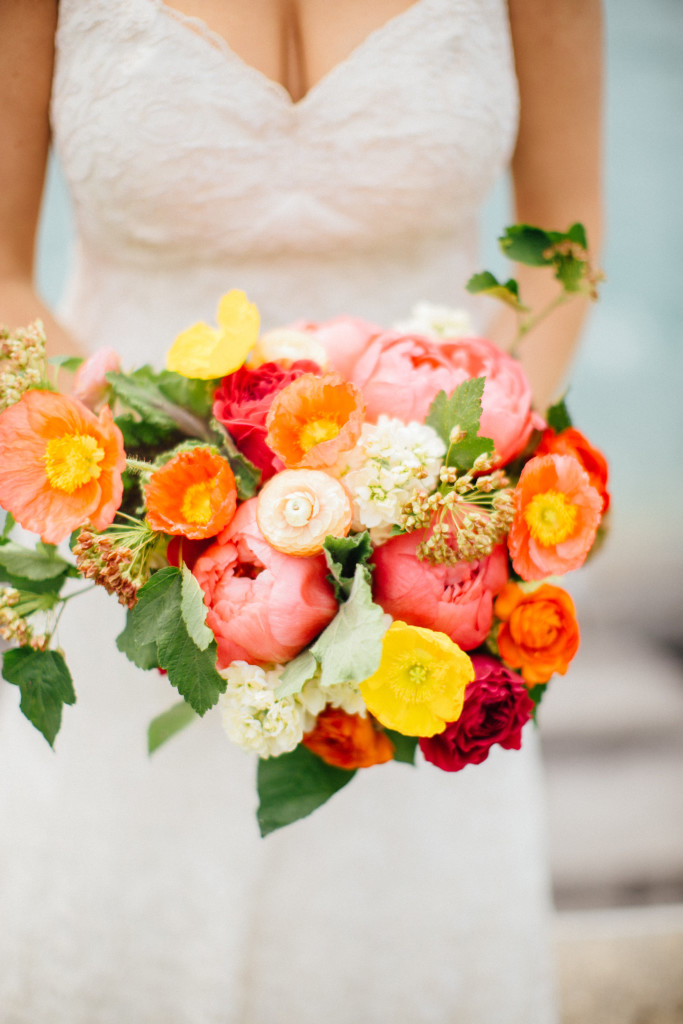 Bright spring wedding bouquet with coral peonies, yellow and orange poppies, and garden roses.