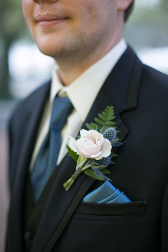 wedding flowers groom boutonniere with spray rose, blue thistle, fern