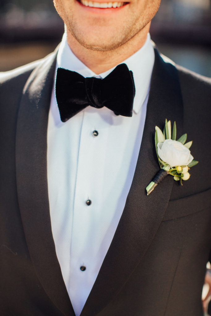 Flowers by Pollen. Photography by Tim Tab Studios. Groom in black tux with white ranunculus boutonniere.