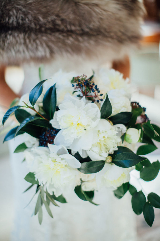 Flowers by Pollen. Photography by Tim Tab Studios. Detail shot of winter bridal bouquet with white peonies and viburnum berries.