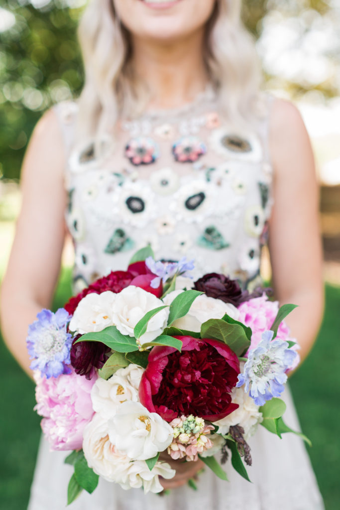 Colorful spring bridesmaid bouquet with peonies, scabiosa, ranunculus, spray roses.