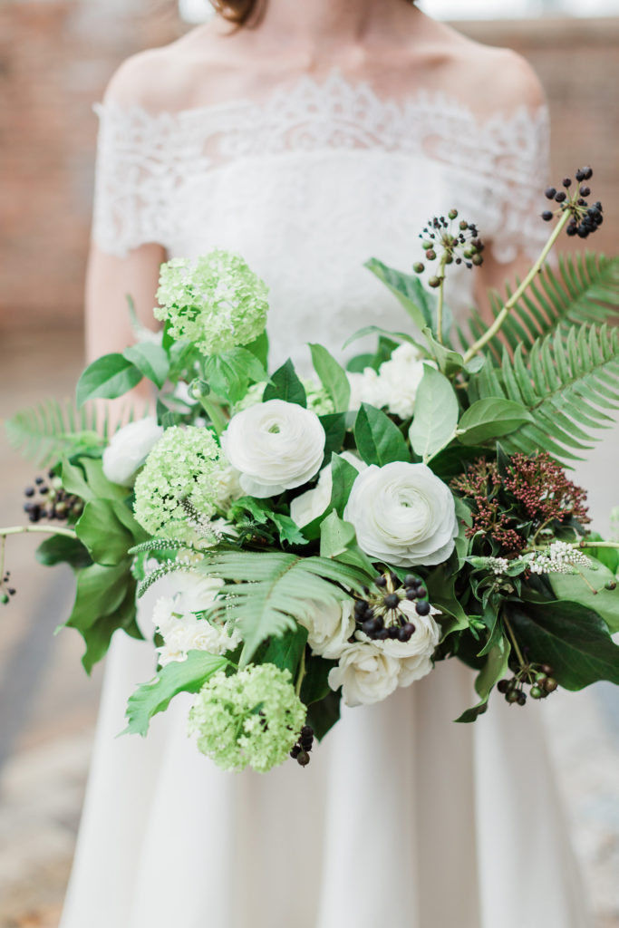 Spring textural bouquet from an Irish Countryside Editorial Shoot with ranunculus, majolica roses, berries, veronica, fern, and snowball viburnum.