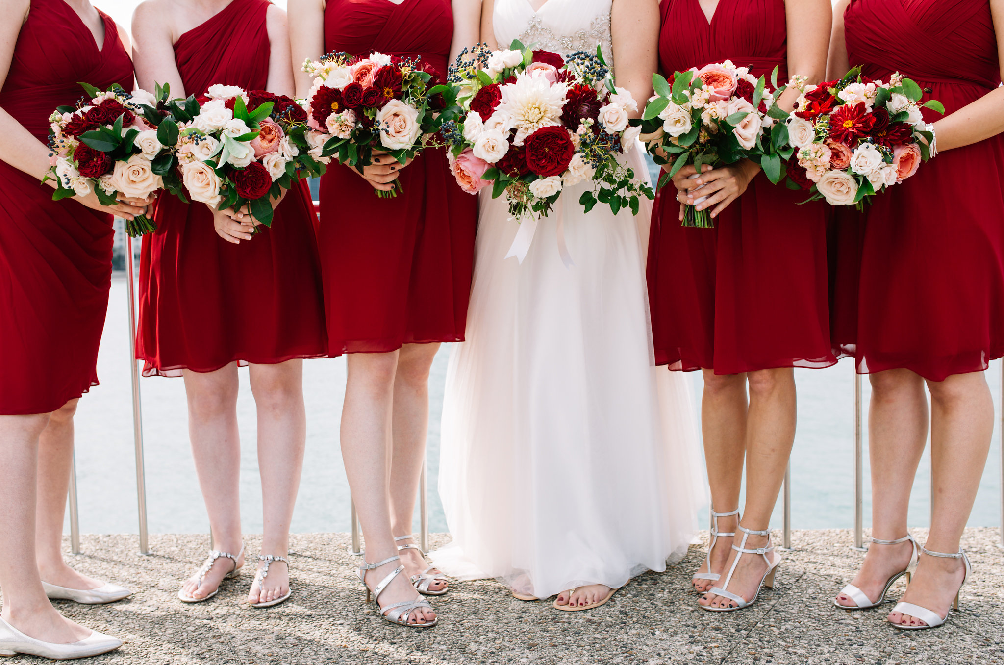 wedding party holding bouquets with red bridesmaid dresses