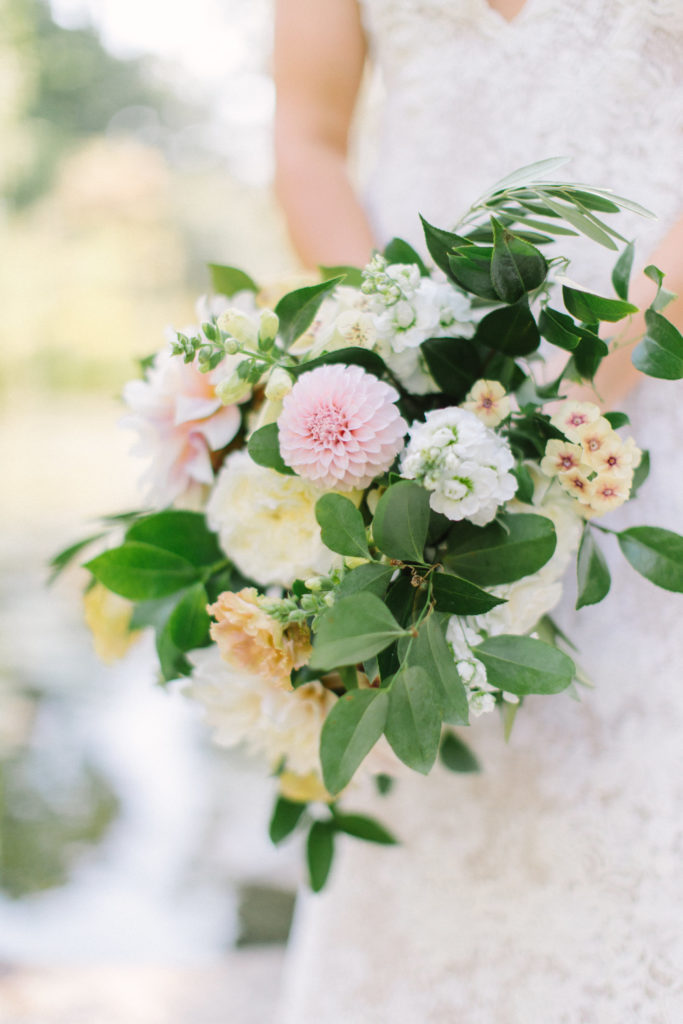 Fall wedding bouquet with neutral palette and flowers like seasonal blush and ivory dahlias, pale yellow phlox, and white stock.