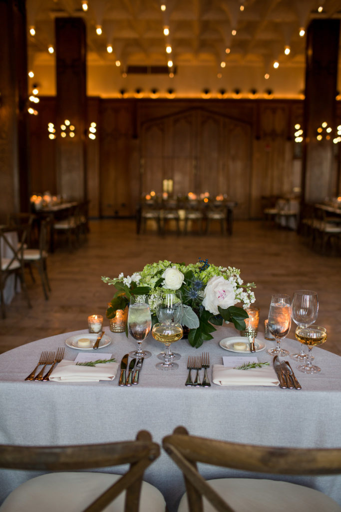 Sweetheart table for spring wedding reception at Chicago Athletic Association with pale pink peonies, ivory ranunculus, green hydrangea, thistle, stock, and dusty miller.