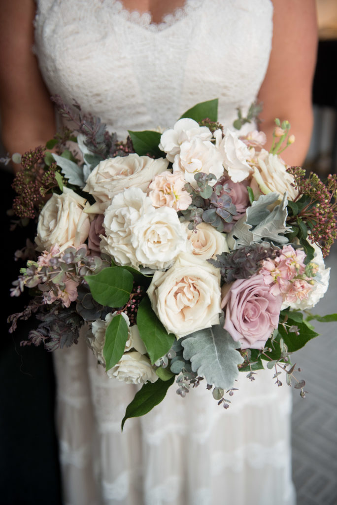 Garden rose and eucalyptus bridal bouquet in muted colors of sage green, grey, mauve, dusty lilac, and ivory for winter wedding.