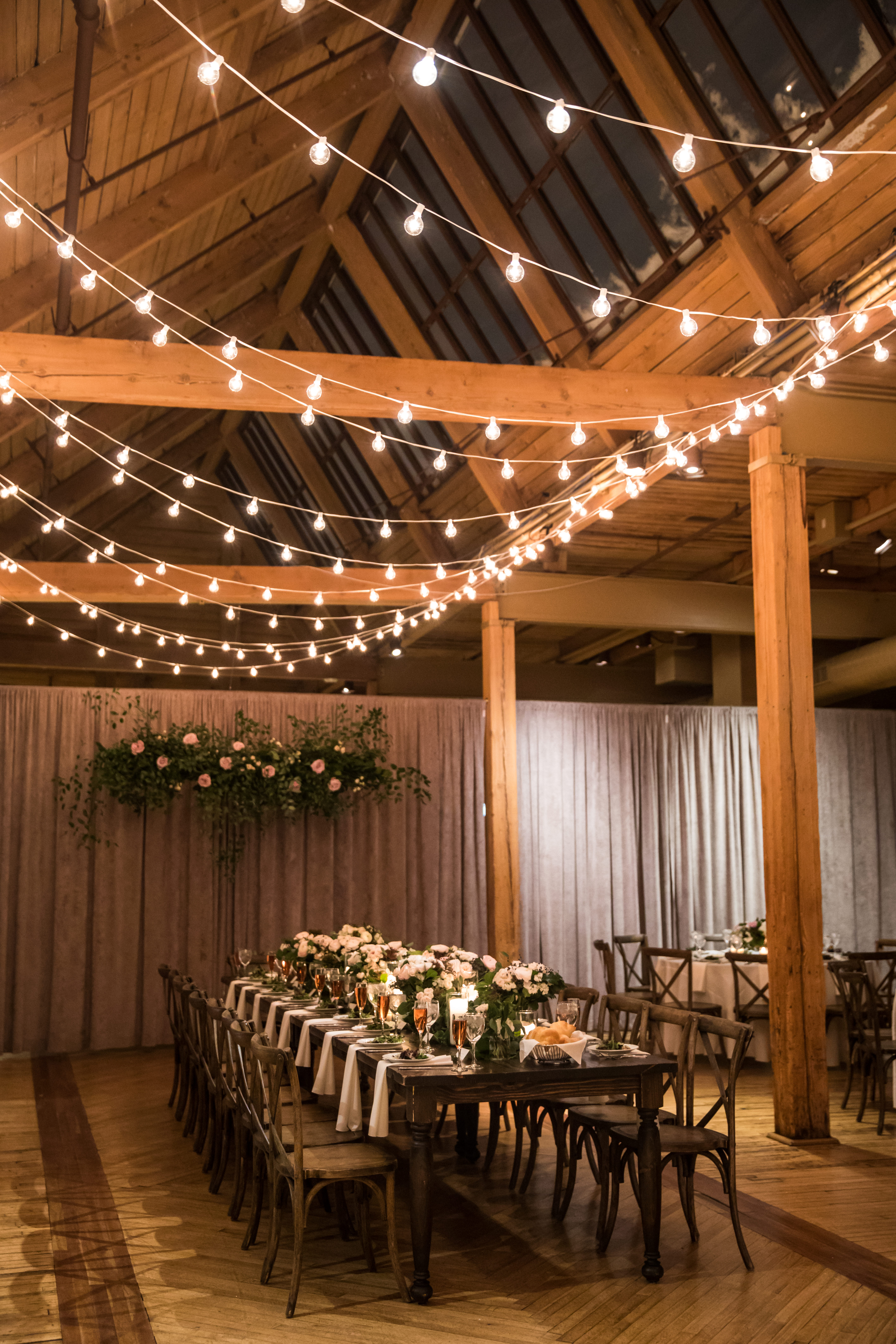 Bridgeport Art Center Skyline Loft winter wedding with kings table, hanging installation with garden roses, and string lights.