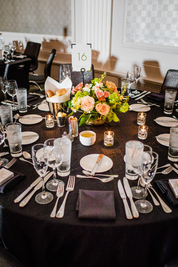 Bright pink and green spring wedding reception arrangements in gold vases with garden roses, narcissus, and snowball viburnum at W City Center. 